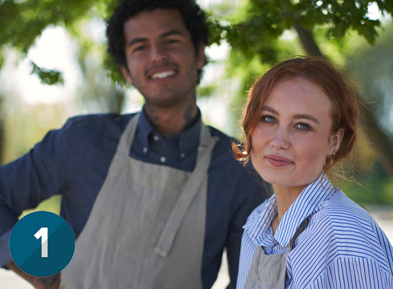 Man and woman smiling at camera on sunny day