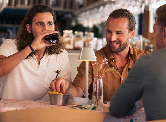 Friends enjoying lunch at a restaurant table with a LED table lamp